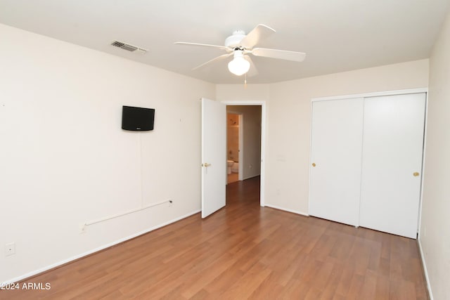 unfurnished bedroom with ceiling fan, a closet, and light hardwood / wood-style floors