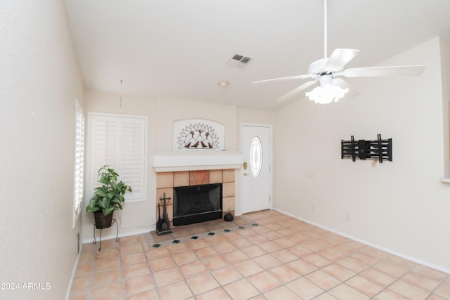 living room featuring a tiled fireplace, light tile patterned floors, and ceiling fan