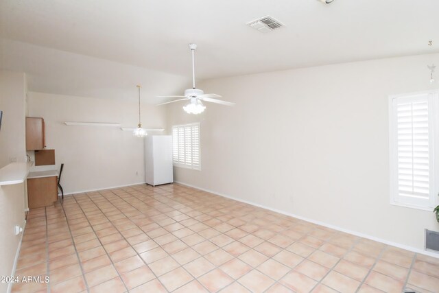 unfurnished room featuring ceiling fan, light tile patterned flooring, and lofted ceiling