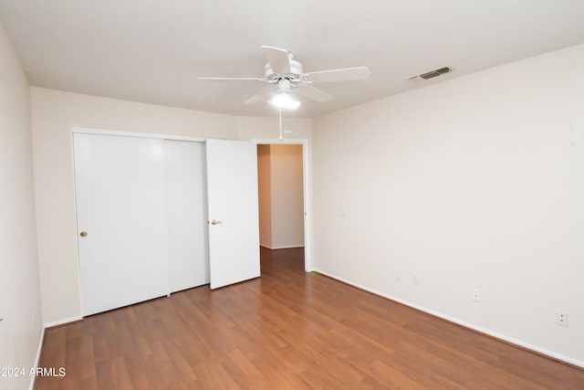 unfurnished bedroom featuring ceiling fan, a closet, and hardwood / wood-style flooring