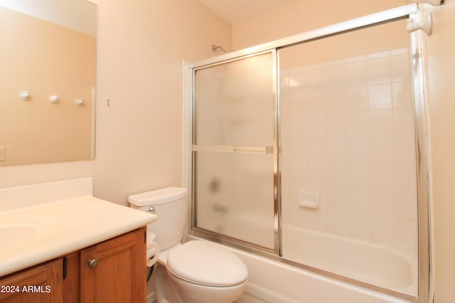 full bathroom featuring toilet, bath / shower combo with glass door, and vanity