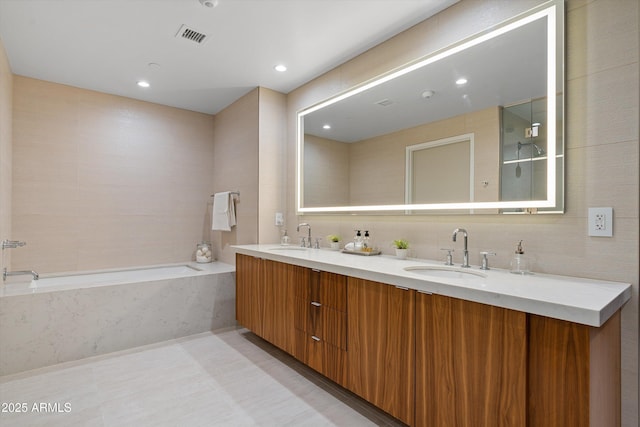 bathroom with tiled tub and vanity