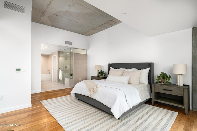 bedroom featuring wood-type flooring and connected bathroom