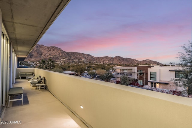 balcony at dusk featuring a mountain view