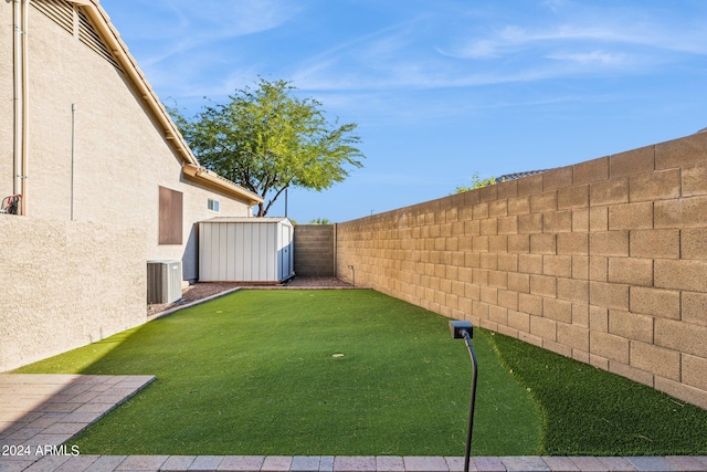 view of yard featuring central air condition unit and a shed