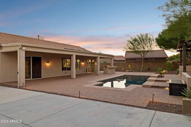 pool at dusk with a patio