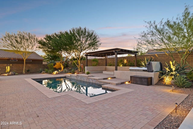 pool at dusk with area for grilling, a patio, and a pergola