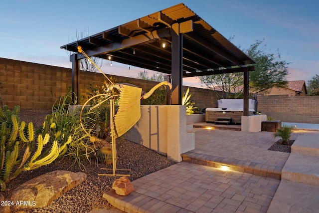 patio terrace at dusk with exterior kitchen and a pergola