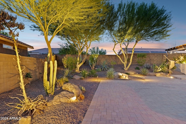 yard at dusk featuring a patio