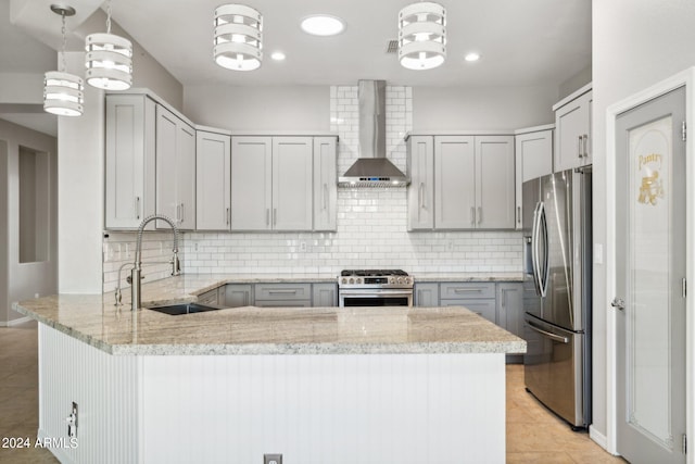 kitchen featuring kitchen peninsula, sink, decorative backsplash, appliances with stainless steel finishes, and wall chimney range hood