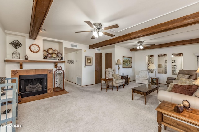 living room featuring beamed ceiling, light carpet, ceiling fan, and a fireplace