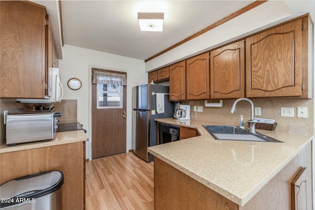 kitchen featuring backsplash, black dishwasher, sink, kitchen peninsula, and light hardwood / wood-style flooring