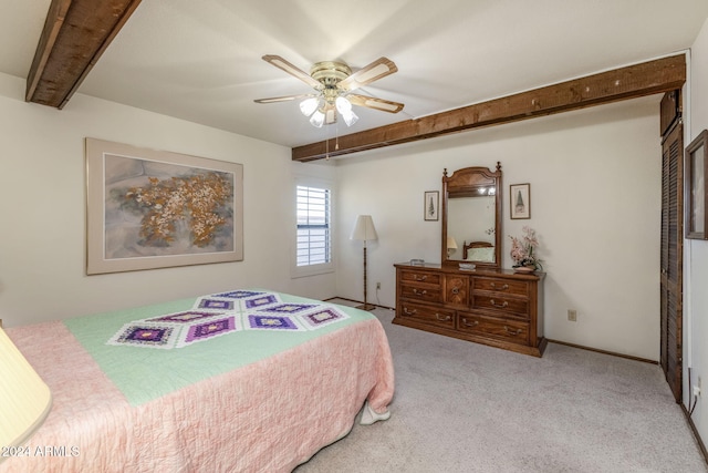 carpeted bedroom with beamed ceiling and ceiling fan