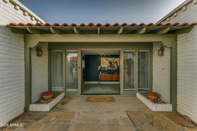 view of exterior entry featuring a tile roof