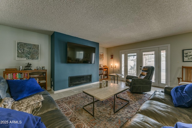 living room with tile patterned floors, a glass covered fireplace, a textured ceiling, and french doors