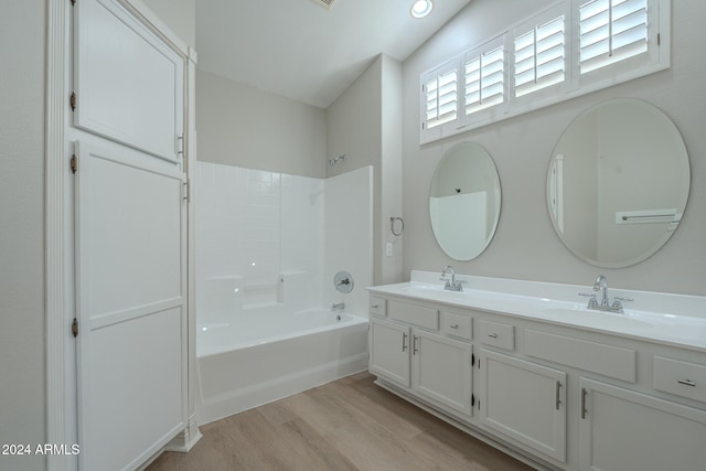 bathroom with vanity, shower / bathing tub combination, wood-type flooring, and lofted ceiling