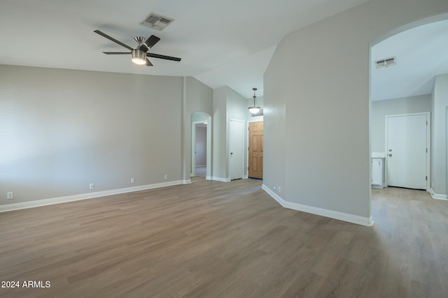 empty room featuring ceiling fan, vaulted ceiling, and light wood-type flooring