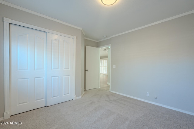 unfurnished bedroom with light carpet, a closet, and crown molding