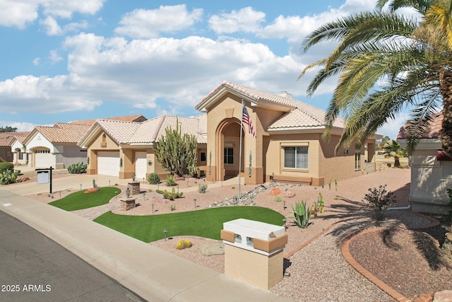 mediterranean / spanish-style house featuring a tile roof, driveway, an attached garage, and stucco siding