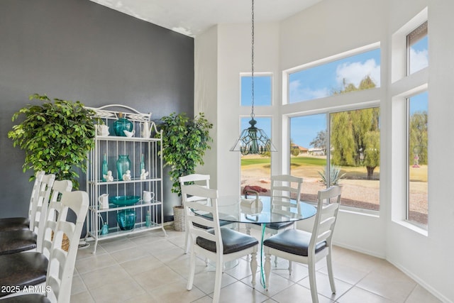 dining room with baseboards, a high ceiling, and light tile patterned flooring