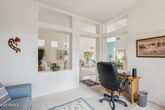 office area with carpet floors, a high ceiling, and visible vents