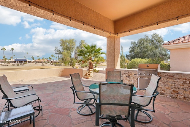 view of patio / terrace featuring exterior kitchen, outdoor dining area, and grilling area