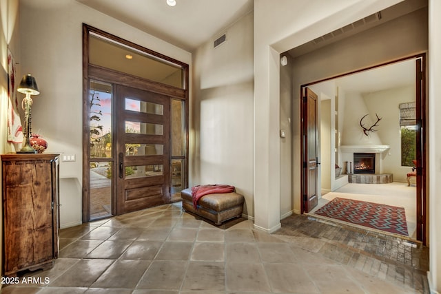 9534 E Monument Dr, Scottsdale, AZ 85262 - entryway with baseboards and a lit fireplace