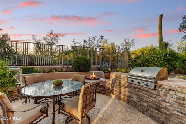 9534 E Monument Dr, Scottsdale, AZ 85262 - patio terrace at dusk featuring a patio, a fire pit, a fenced backyard, and outdoor dining area