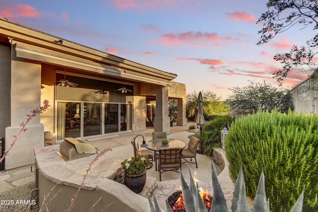 9534 E Monument Dr, Scottsdale, AZ 85262 - patio terrace at dusk featuring a patio, an outdoor fire pit, and ceiling fan