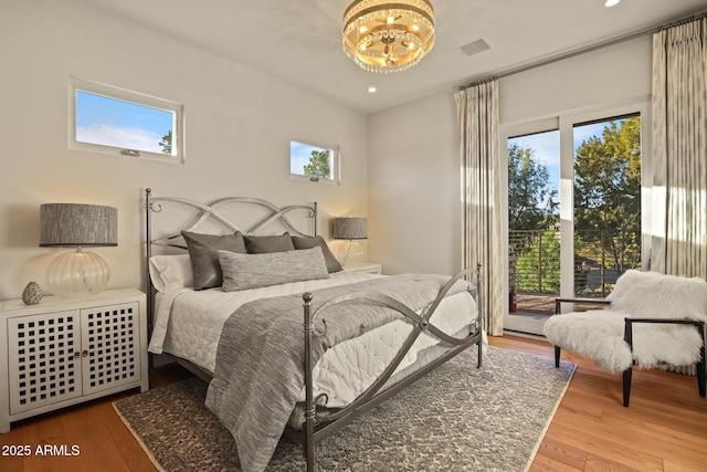 bedroom with visible vents, wood finished floors, access to exterior, a notable chandelier, and recessed lighting