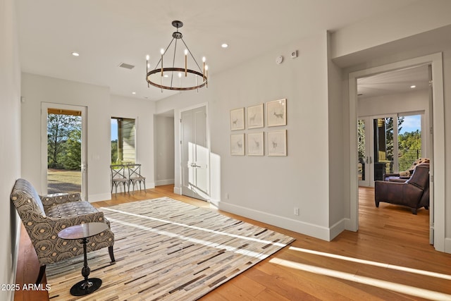 living area featuring light wood finished floors, recessed lighting, visible vents, and baseboards