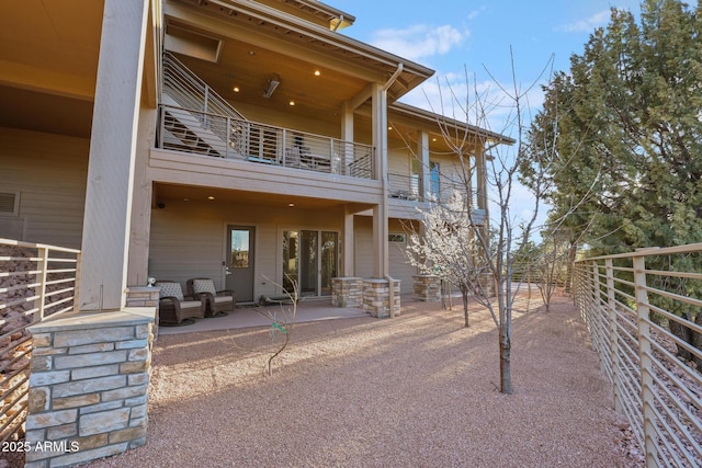 back of property featuring a balcony and a patio