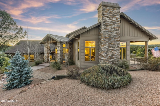 exterior space with a standing seam roof, metal roof, board and batten siding, and a patio area