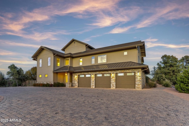 view of front of home with a garage, a standing seam roof, decorative driveway, and board and batten siding