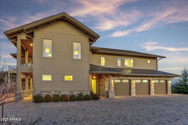 view of front of house featuring a balcony, a standing seam roof, metal roof, and decorative driveway