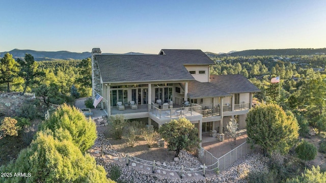 back of house with a patio, a forest view, and a mountain view