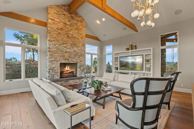 living area featuring high vaulted ceiling, a healthy amount of sunlight, a stone fireplace, and hardwood / wood-style flooring