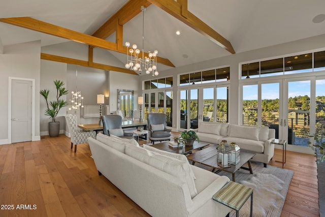 living area with a chandelier, french doors, and high vaulted ceiling