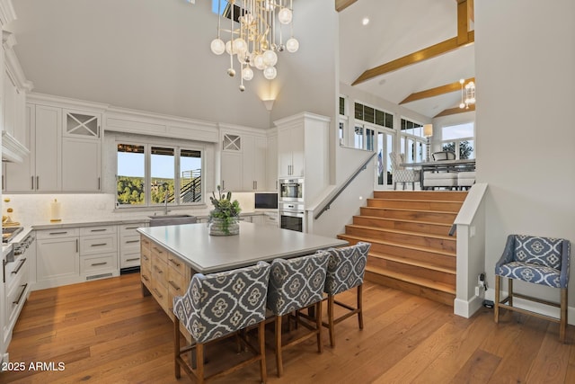 kitchen featuring a chandelier, a sink, light wood finished floors, and a kitchen island