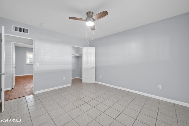 tiled spare room featuring ceiling fan