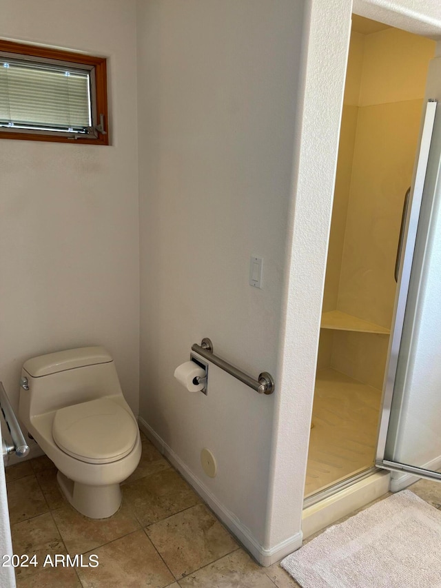 bathroom featuring walk in shower, tile floors, and toilet