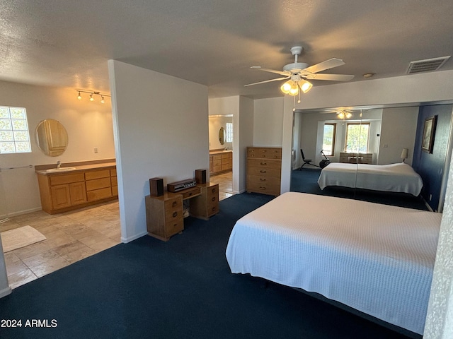 bedroom featuring ensuite bathroom, light carpet, and multiple windows