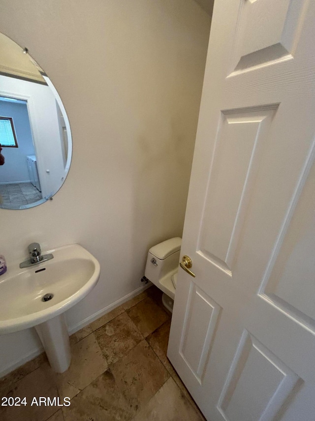 bathroom featuring toilet and tile floors