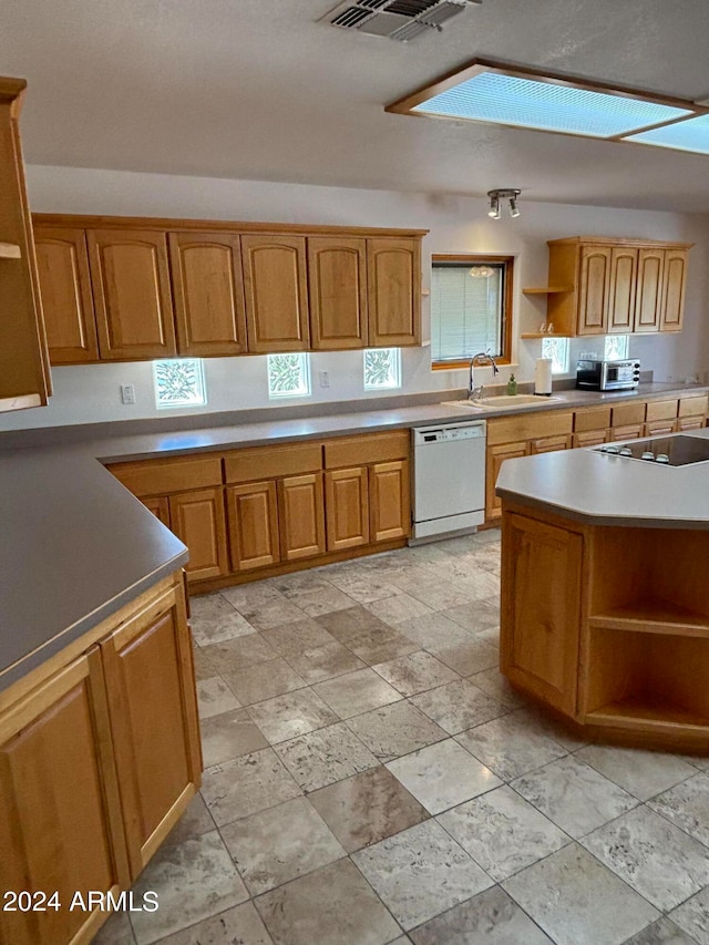 kitchen featuring sink, dishwasher, and light tile floors