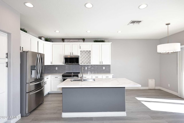 kitchen with white cabinetry, sink, stainless steel appliances, a center island with sink, and light wood-type flooring