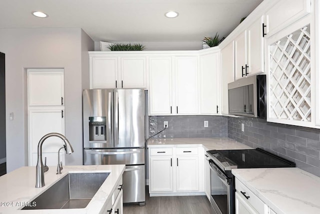 kitchen featuring white cabinets, decorative backsplash, sink, and appliances with stainless steel finishes