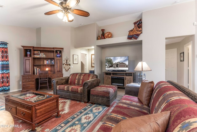 living room with ceiling fan, hardwood / wood-style floors, and a high ceiling