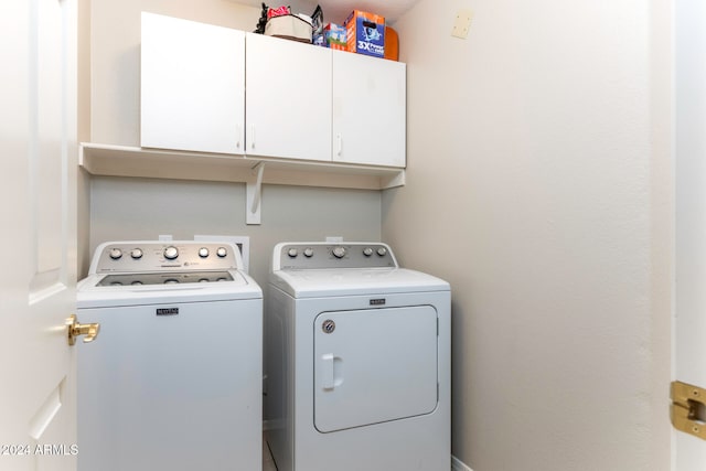 laundry area with washer and dryer and cabinets