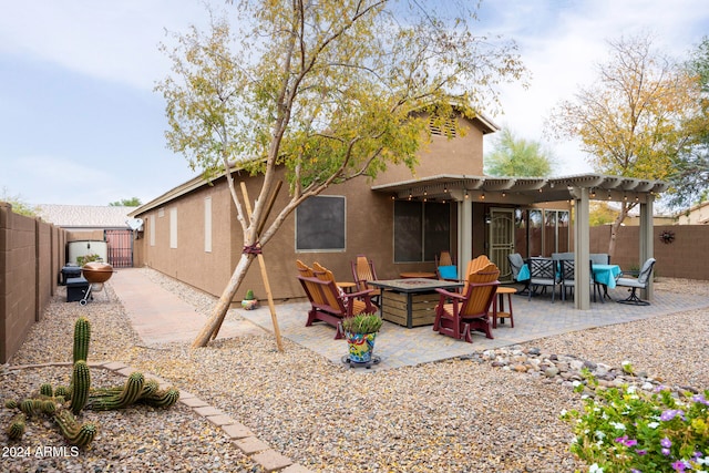 back of house featuring a pergola, a patio area, and an outdoor fire pit