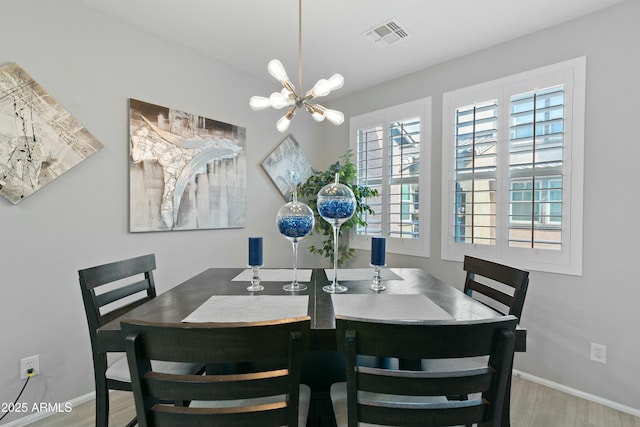 dining area featuring hardwood / wood-style flooring and a chandelier